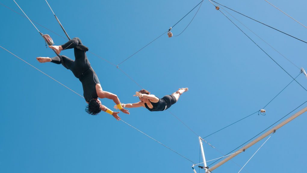 Zwei mutige Akrobaten zeigen beeindruckende Performance auf einem Hochseil in der Luft.