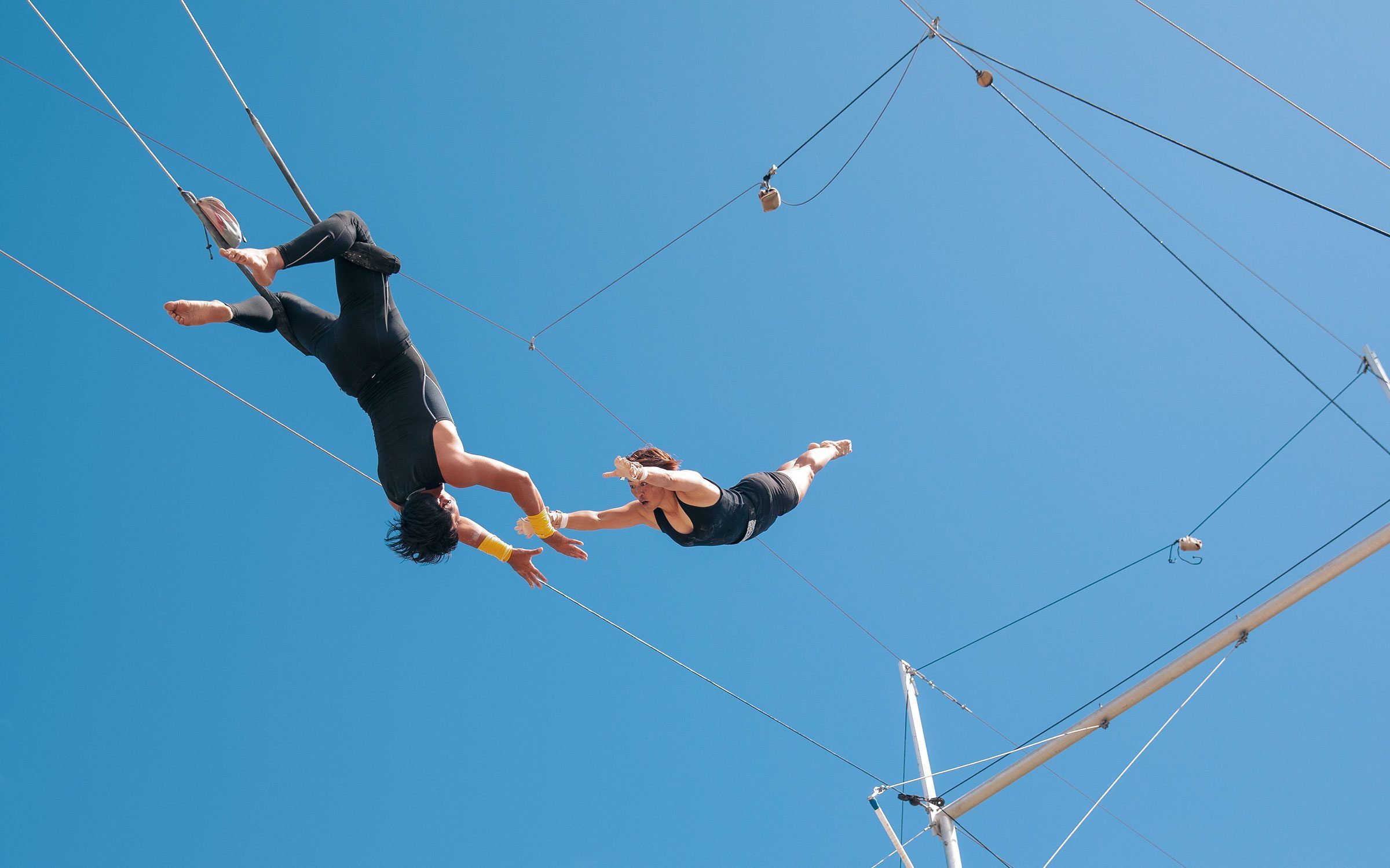 Zwei mutige Akrobaten zeigen beeindruckende Performance auf einem Hochseil in der Luft.