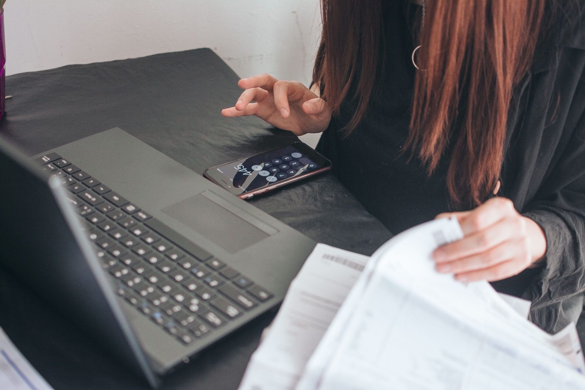 Eine Frau beschäftigt sich an ihrem Schreibtisch mit Zahlungen und E-Banking.