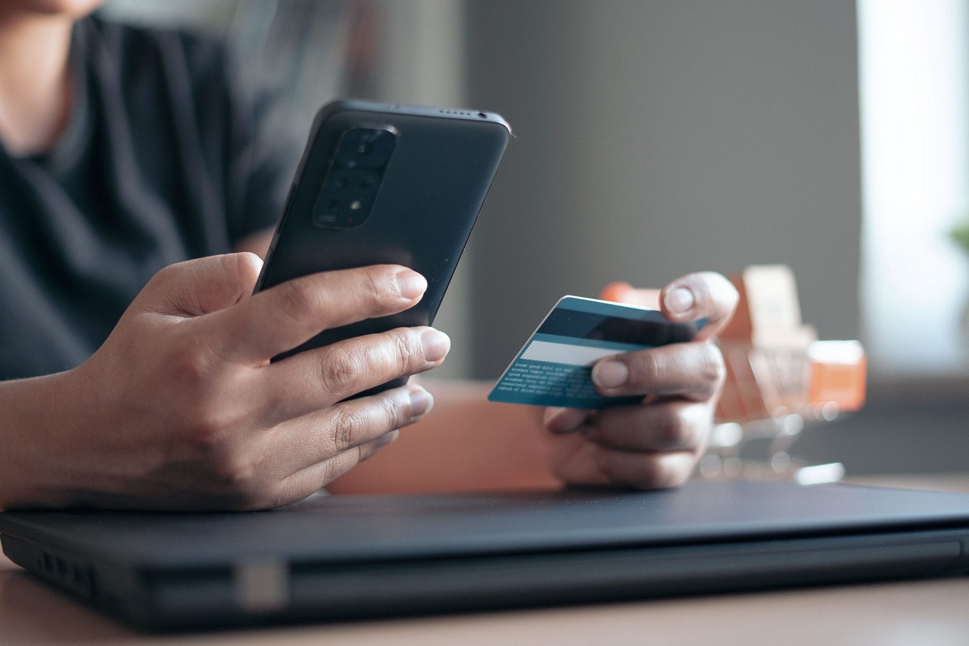 Eine Person bezahlt online mit Mobilepayment und Kreditkarte.
