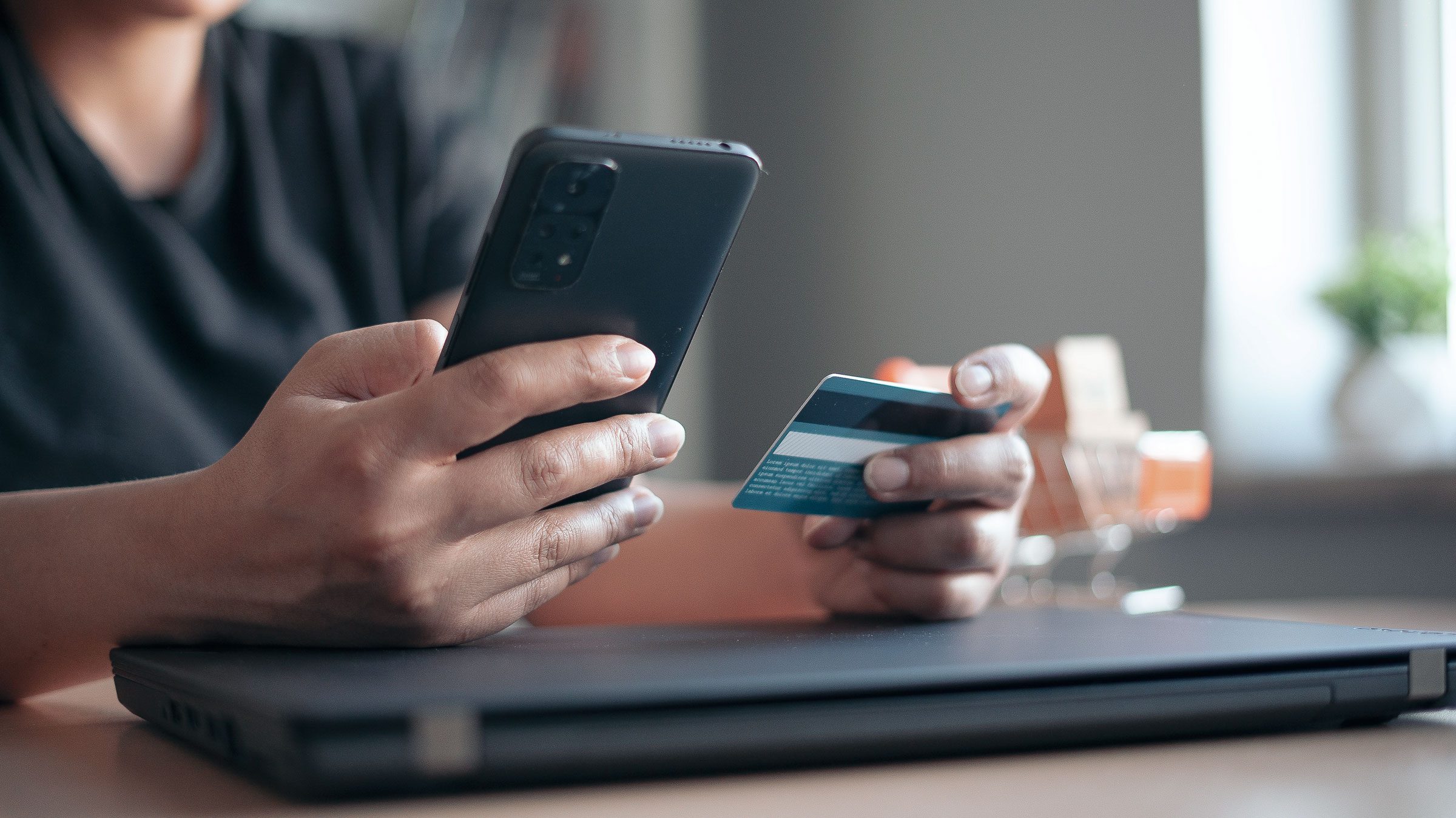 Eine Person bezahlt online mit Mobilepayment und Kreditkarte.